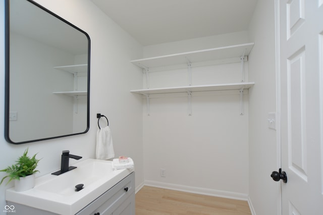 clothes washing area featuring sink and light hardwood / wood-style floors