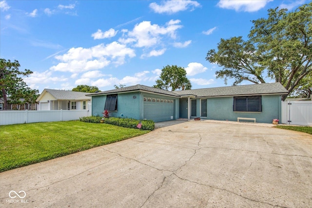 single story home with a front lawn, fence, concrete driveway, stucco siding, and an attached garage