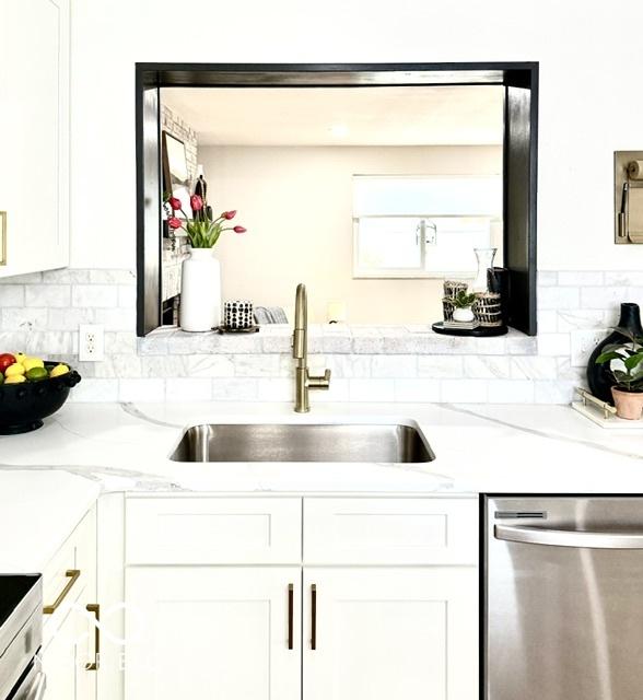 kitchen featuring a sink, white cabinets, decorative backsplash, and stainless steel dishwasher