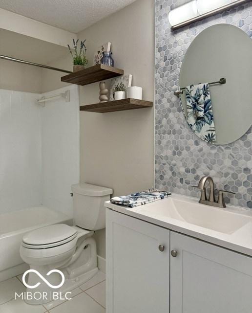 bathroom featuring tasteful backsplash, toilet, vanity, tile patterned floors, and a textured ceiling