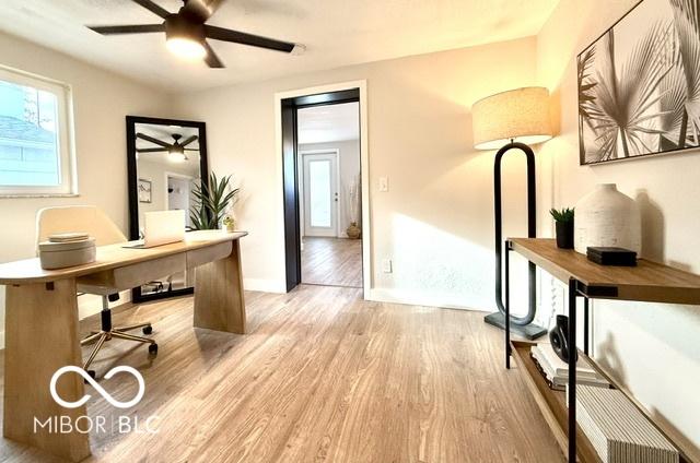 office area with baseboards, light wood-type flooring, and ceiling fan