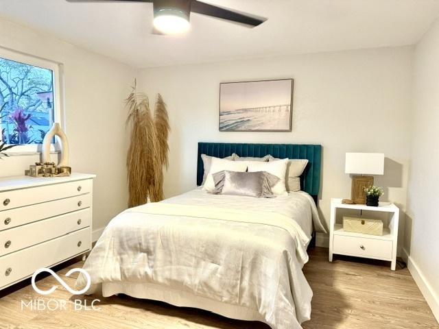 bedroom with baseboards, ceiling fan, and wood finished floors