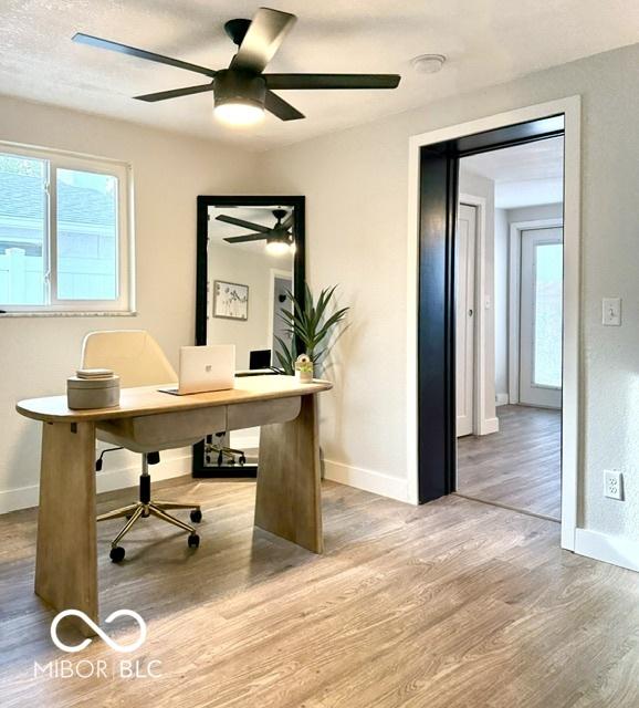 office featuring a ceiling fan, wood finished floors, and baseboards