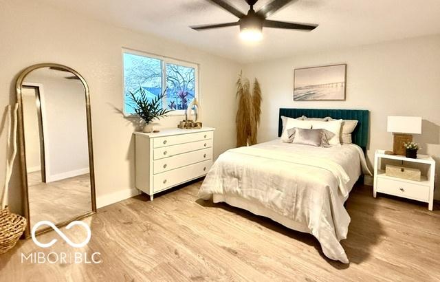 bedroom with a ceiling fan, baseboards, and light wood finished floors