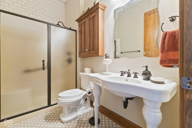 bathroom featuring toilet and a shower with door