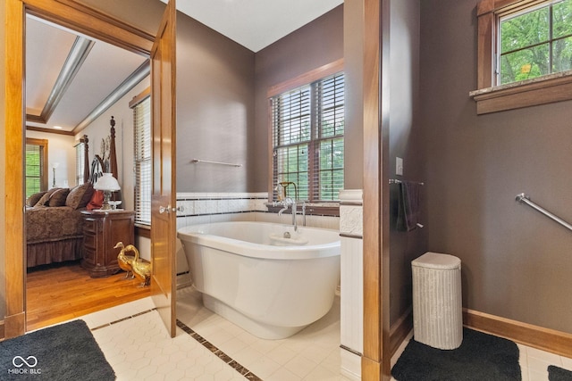 bathroom with a washtub and tile patterned flooring