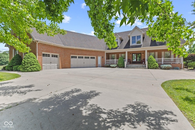 cape cod home featuring a porch and a garage