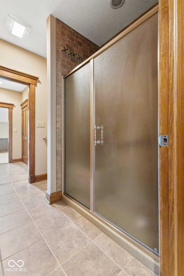 bathroom featuring tile patterned flooring and a shower with door