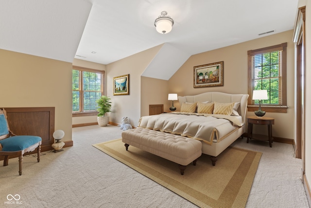 bedroom featuring light colored carpet, multiple windows, and lofted ceiling