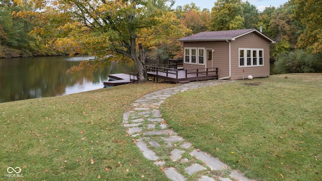 exterior space with a deck with water view and a lawn