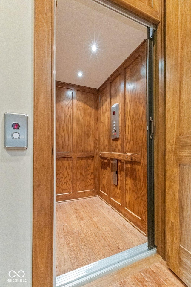 interior details featuring wood-type flooring and elevator