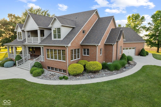 exterior space featuring a yard, a balcony, a porch, and a garage