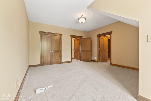 unfurnished bedroom with carpet and vaulted ceiling