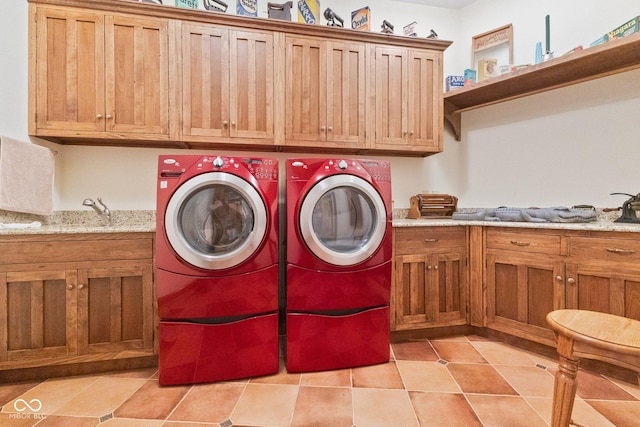 laundry area with washing machine and dryer, cabinets, and light tile patterned floors