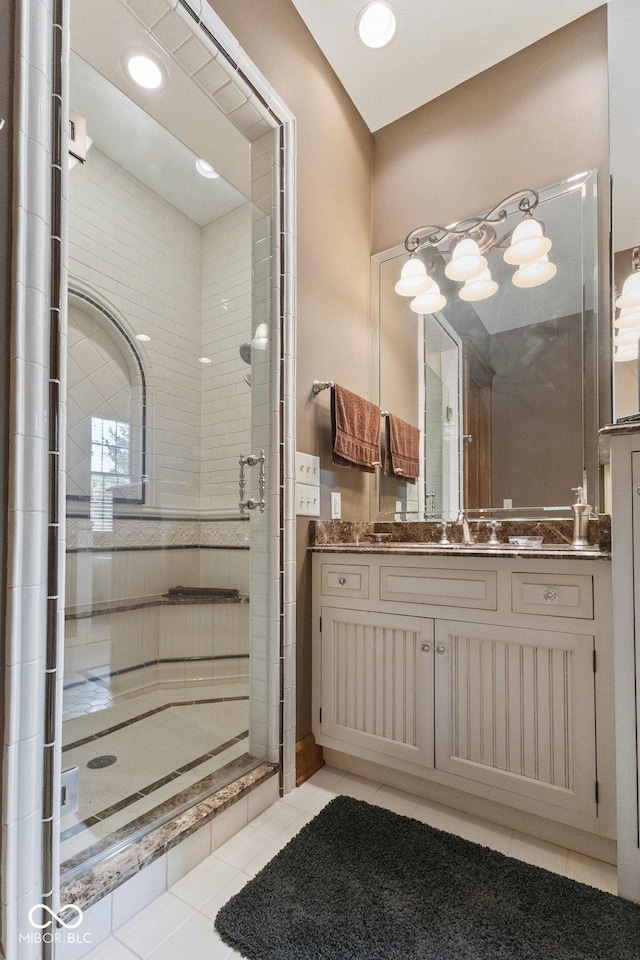 bathroom with tile patterned floors, an enclosed shower, and vanity