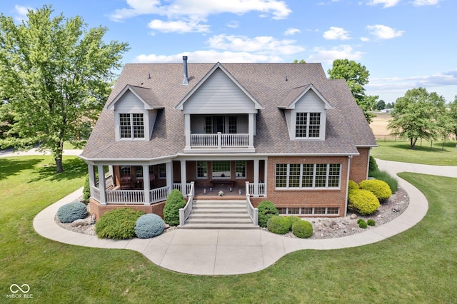 view of front of home with a front lawn, a balcony, and covered porch