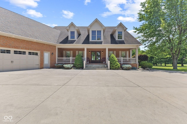 cape cod-style house with covered porch and a garage