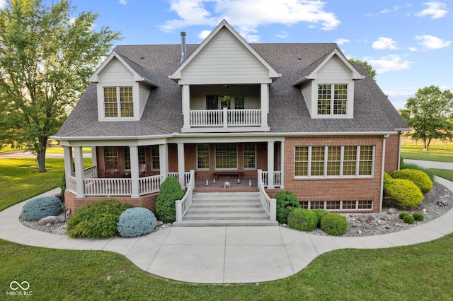 view of front facade featuring a front yard, a porch, and a balcony