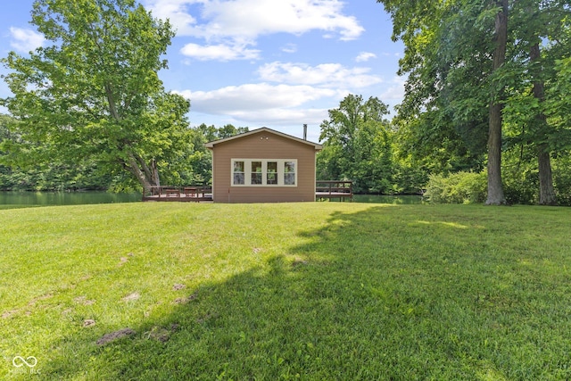 view of yard with a deck with water view