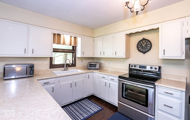 kitchen with white cabinetry, sink, stainless steel appliances, and a textured ceiling