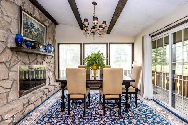 dining space with lofted ceiling with beams, an inviting chandelier, a fireplace, and a textured ceiling