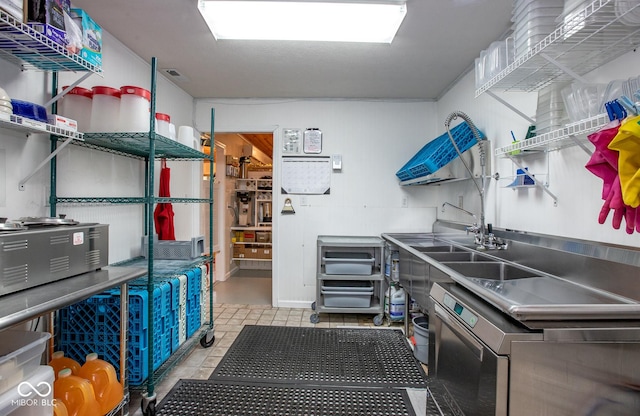 interior space with stainless steel counters and light tile patterned flooring