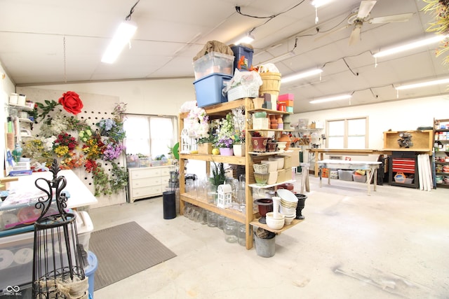 misc room with concrete flooring, ceiling fan, and a workshop area