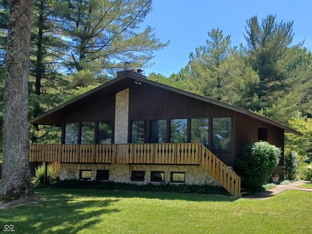 rear view of property featuring a lawn