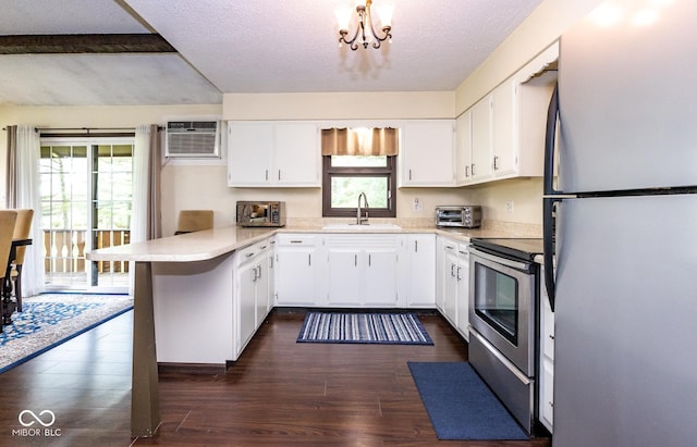 kitchen with stainless steel appliances, a wall mounted air conditioner, white cabinets, dark hardwood / wood-style flooring, and kitchen peninsula