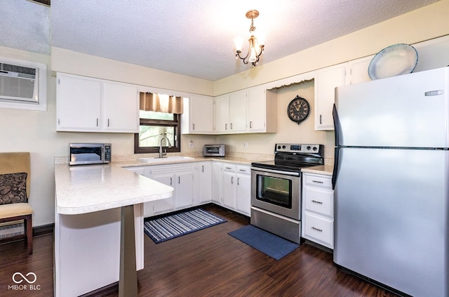 kitchen featuring pendant lighting, a textured ceiling, stainless steel appliances, and white cabinets