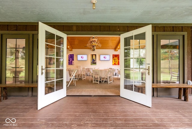 interior space featuring wood ceiling, wooden walls, french doors, and hardwood / wood-style flooring