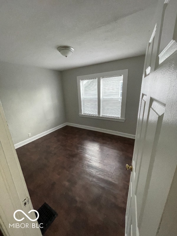 spare room with dark carpet