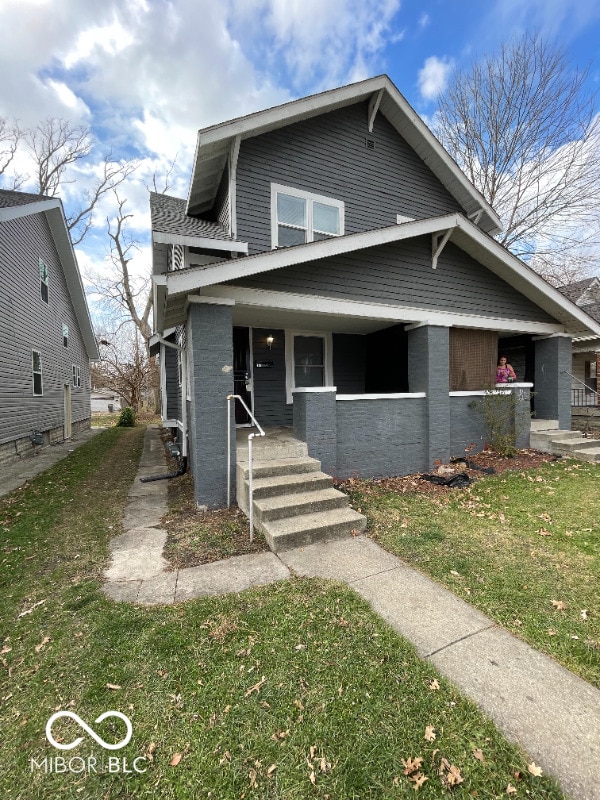 view of front of home with a front yard and covered porch