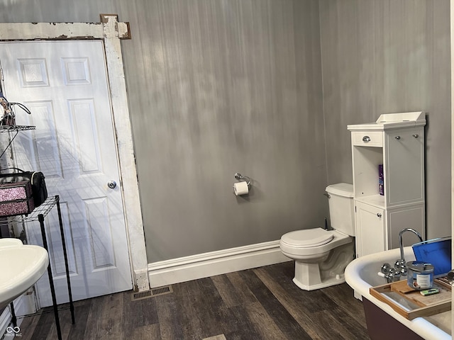 bathroom with hardwood / wood-style flooring and toilet