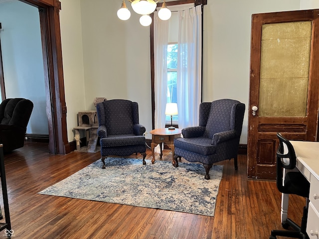 living area featuring dark wood-type flooring and a chandelier