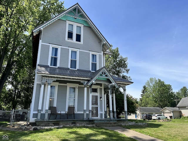 victorian home with a porch and a front lawn