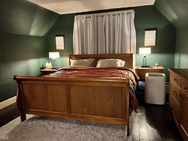 bedroom with vaulted ceiling, dark hardwood / wood-style flooring, and a textured ceiling