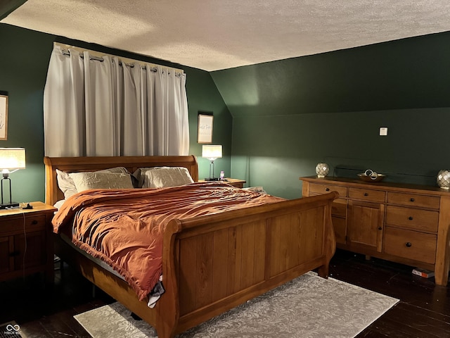 bedroom with lofted ceiling, a textured ceiling, and dark wood-type flooring