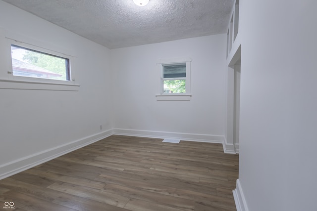 empty room with a textured ceiling and hardwood / wood-style flooring