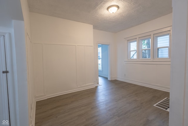 empty room featuring dark hardwood / wood-style flooring and a textured ceiling