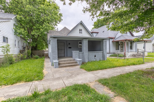 bungalow-style house with covered porch and a front yard