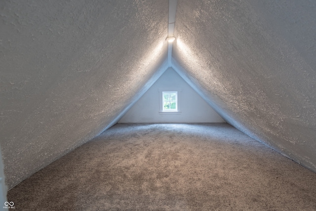 bonus room with carpet, lofted ceiling, and a textured ceiling