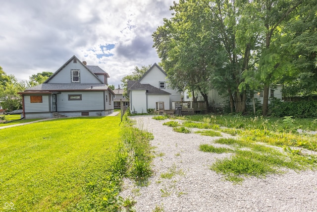 view of front of property featuring a wooden deck and a front lawn