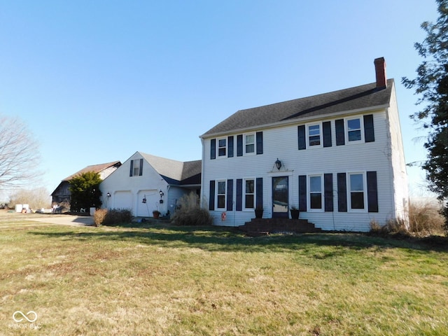 colonial house featuring a front lawn, an attached garage, and a chimney