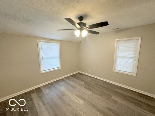 spare room featuring a textured ceiling, hardwood / wood-style flooring, and ceiling fan