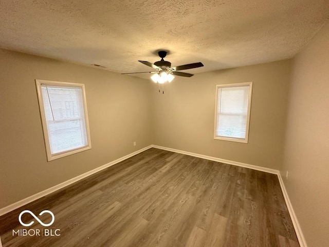 spare room featuring a textured ceiling, ceiling fan, and dark wood-type flooring