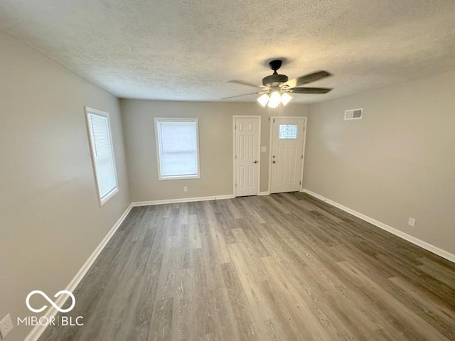 foyer entrance with ceiling fan, hardwood / wood-style floors, and a textured ceiling