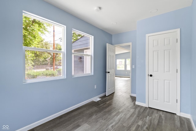 unfurnished room with dark wood-type flooring