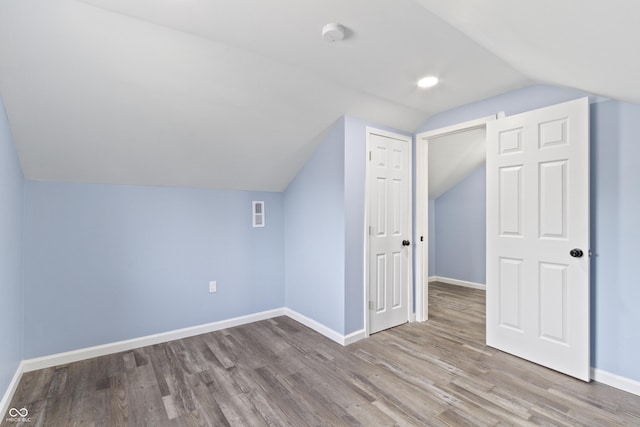 additional living space featuring light hardwood / wood-style floors and lofted ceiling