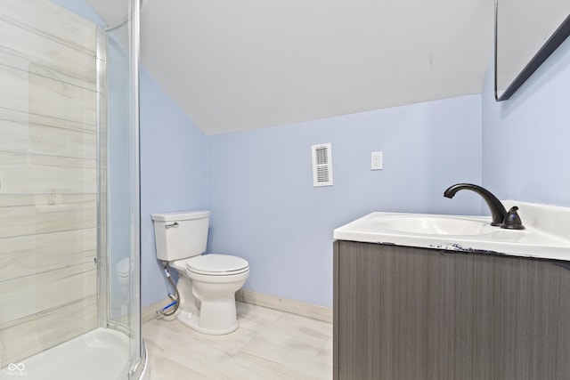 bathroom with vanity, toilet, a shower with shower door, and vaulted ceiling